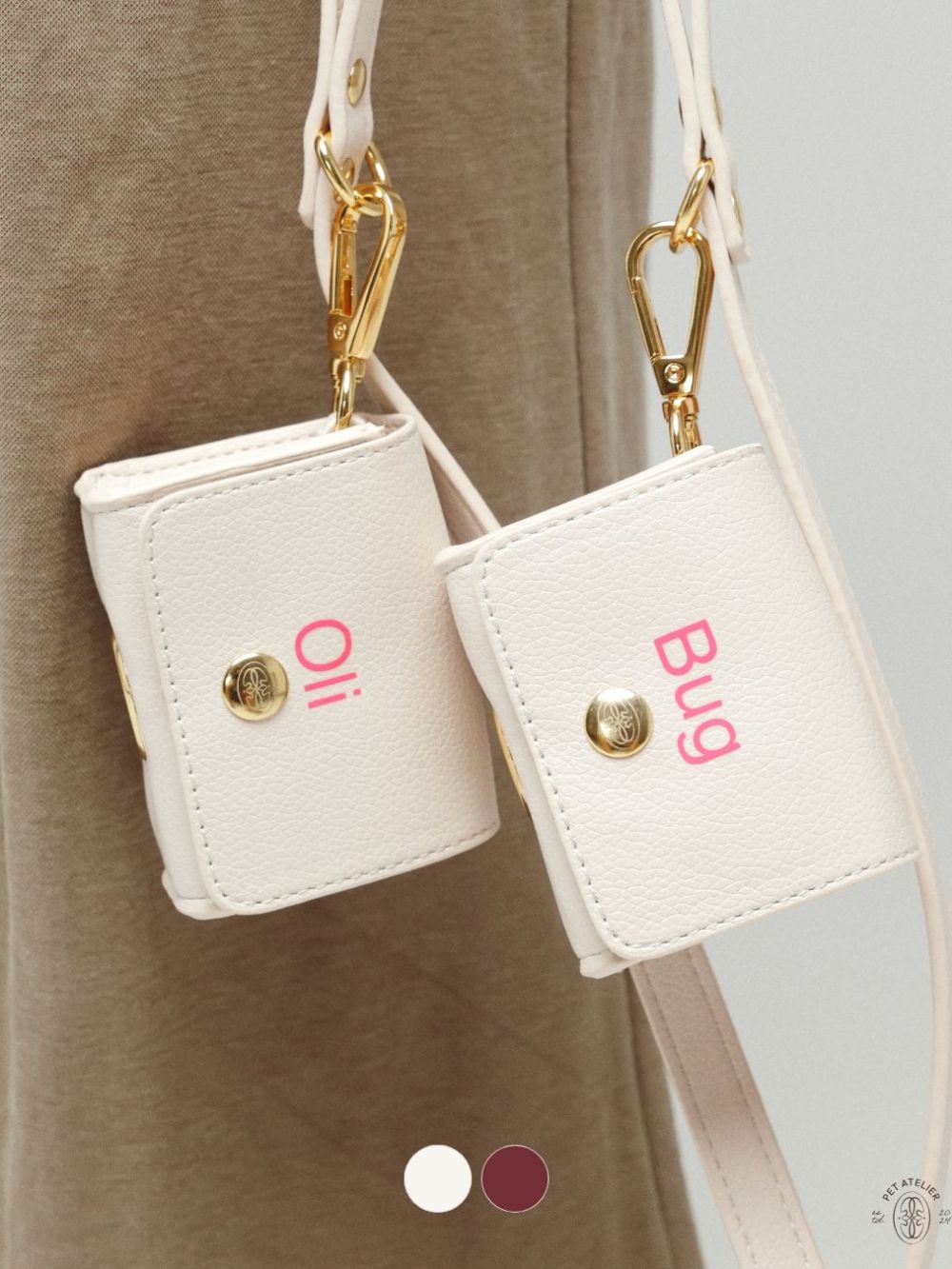 Personalized dog poop bag holders in white with custom engraved names Oli and Bug.