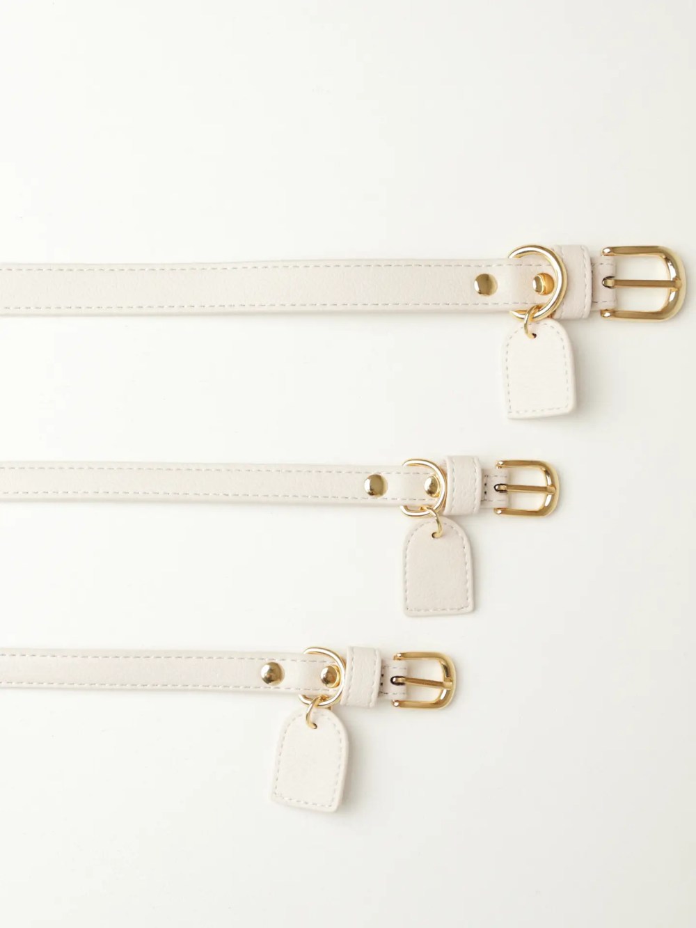 White PU leather dog collars available in multiple sizes.