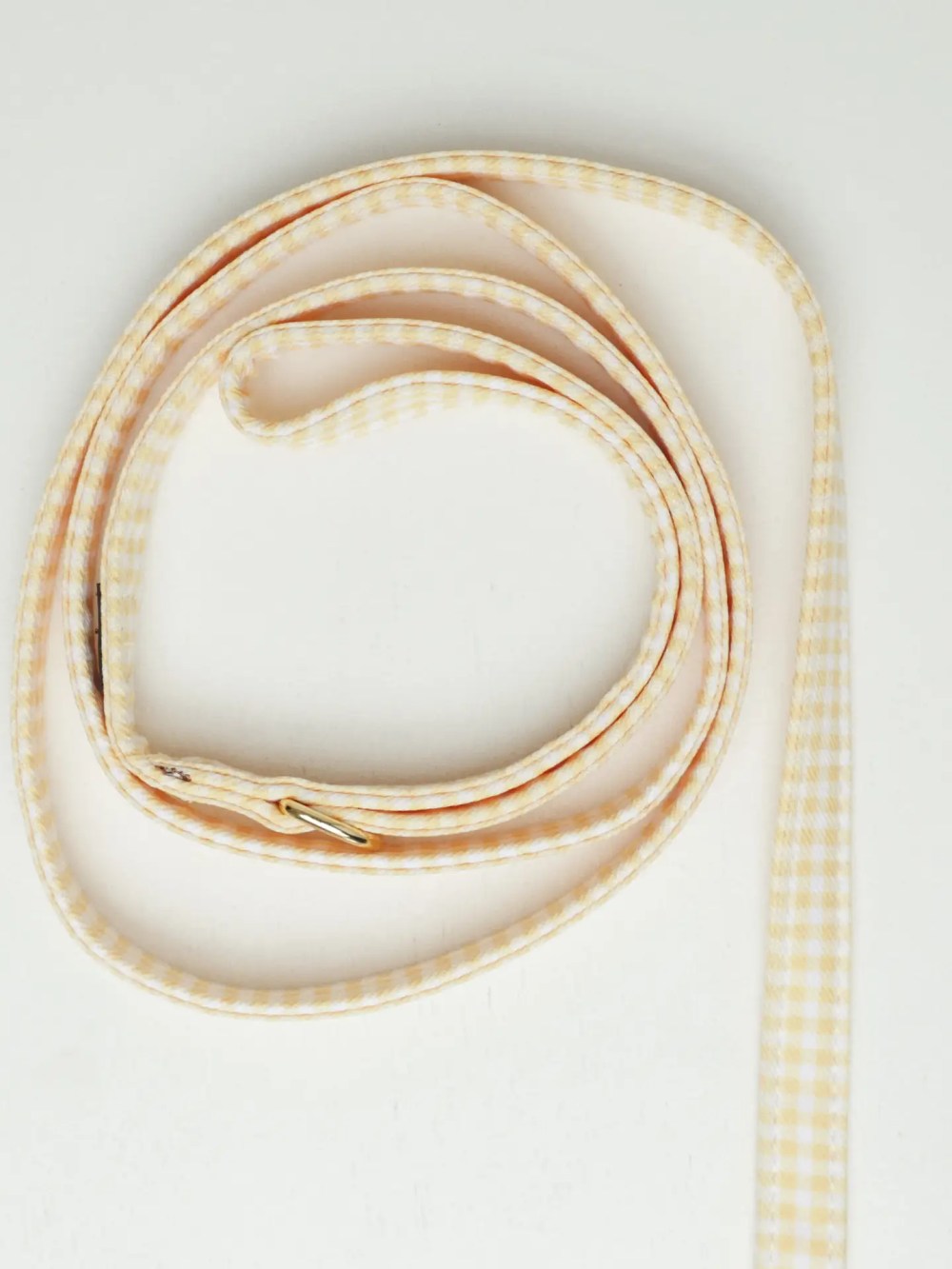 Yellow gingham dog leash with gold hardware by Oliva Pet Atelier.
