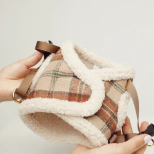 Tartan dog harness with a soft sherpa lining, held in the hand