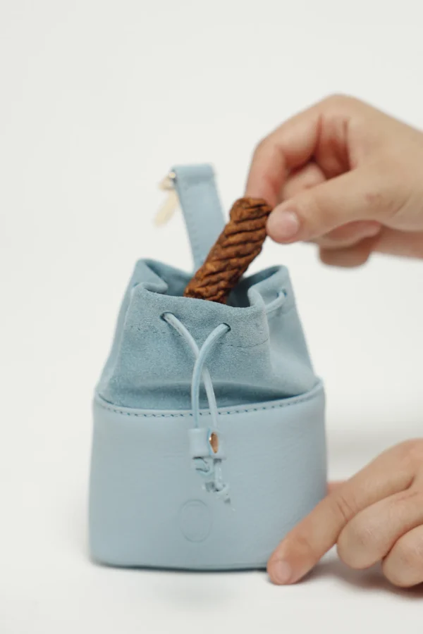 Taking a treat out of the Sky Blue leather treat bag