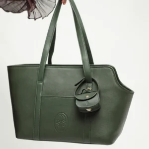Dark Green leather dog carrier held by its shoulder straps, with the embossed logo and the poop bag holder