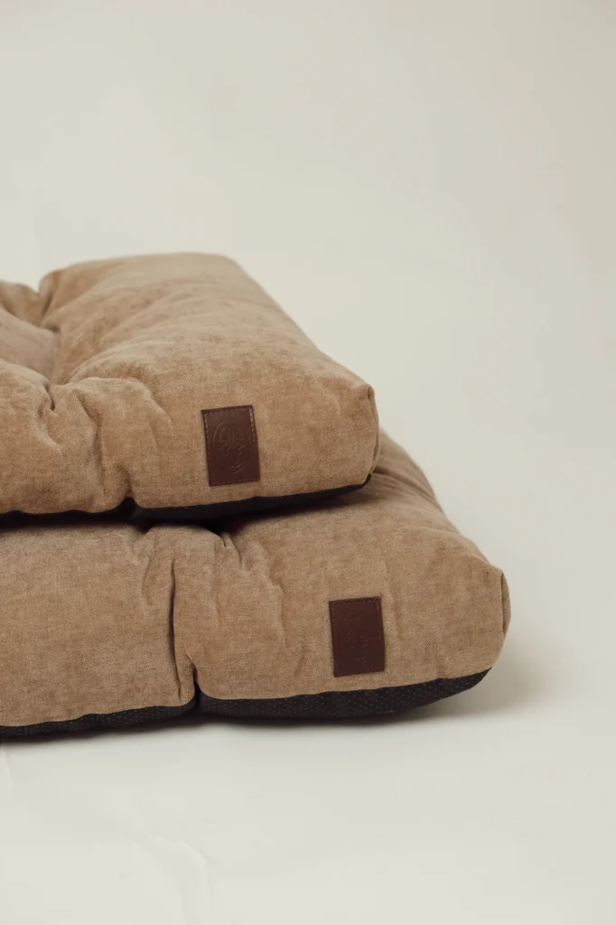 Beige Atelier padded dog beds in sizes S and M with the leather Oliva logo