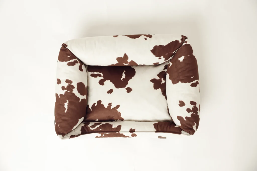 Top view of the sofa-style Moo dog bed with cow print