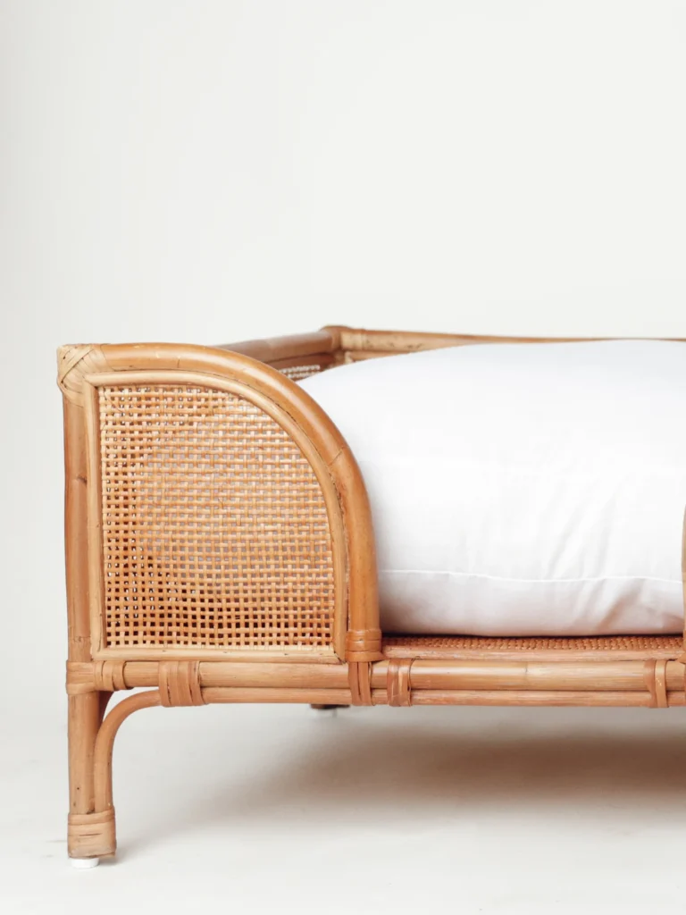 Natural rattan Oliva dog bed with a soft white cushion
