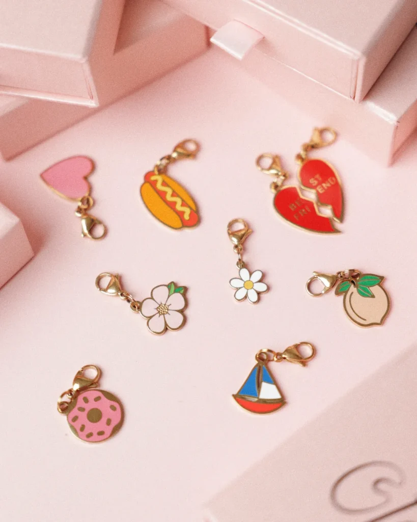 Charms esmaltados para perro de Oliva sobre rosa palo: corazón, perrito caliente, Best Friends, flor Bloom, margarita, melocotón, dónut y velero