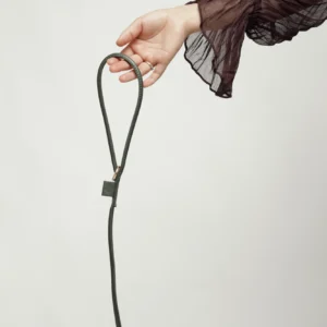 Hand holding the handle of the Dark Green round leather leash
