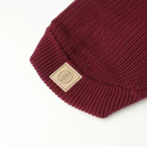Close-up of the Oliva label on the burgundy knit dog jumper