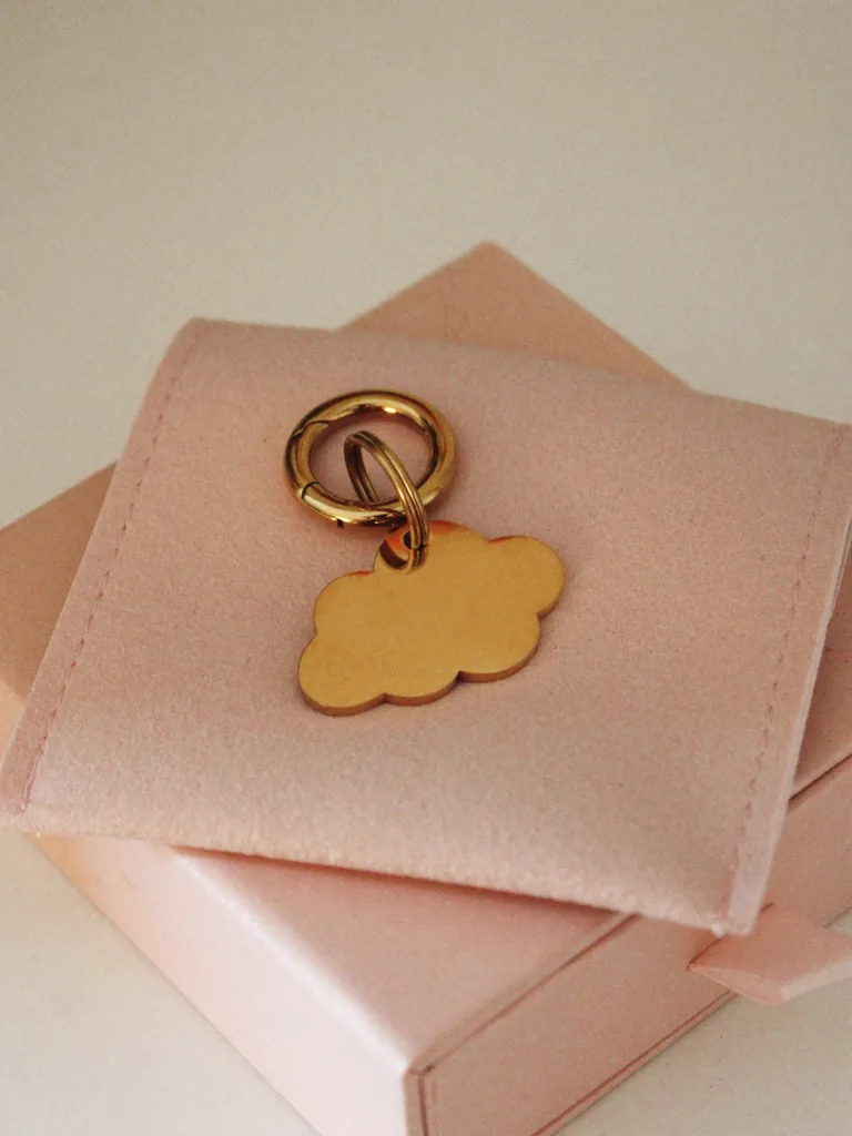 Placa identificativa dorada para perro en forma de nube, personalizada y grabada con láser, con anilla dorada sobre una funda rosa palo