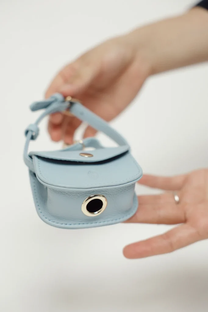 Metal eyelet for pulling out the bags on the Sky Blue leather poop bag holder